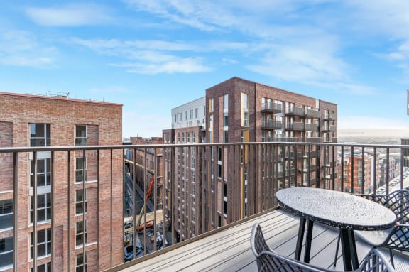 a balcony with a table and chairs and a view of buildings