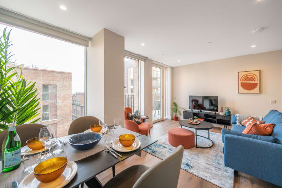a living room with a large window and a dining room table
