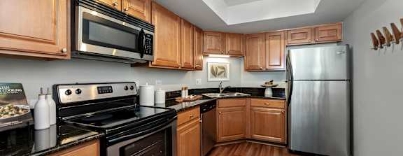 A kitchen with wooden cabinets and black appliances.