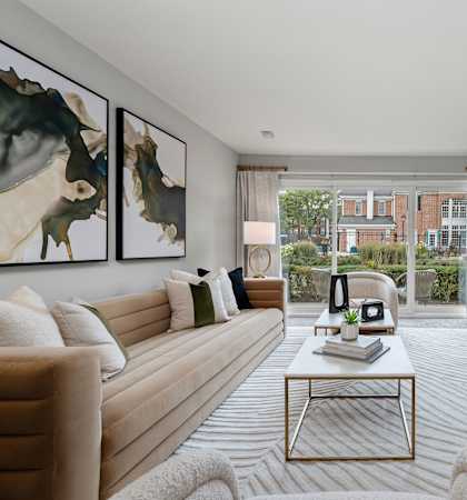 A living room with a large painting on the wall and a flat screen TV mounted on the wall.