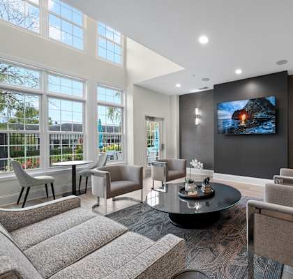 A modern living room with a large screen TV and comfortable seating.