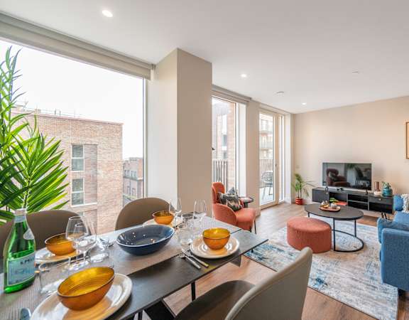 a living room with a large window and a dining room table