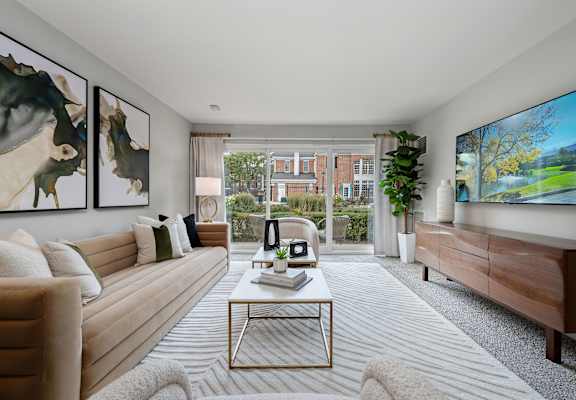 A living room with a large painting on the wall and a flat screen TV mounted on the wall.