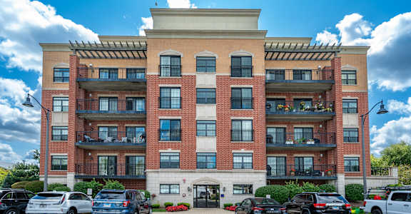 A large red brick building with a parking lot in front.