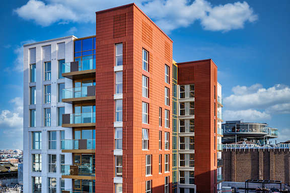 a tall apartment building with a blue sky in the background