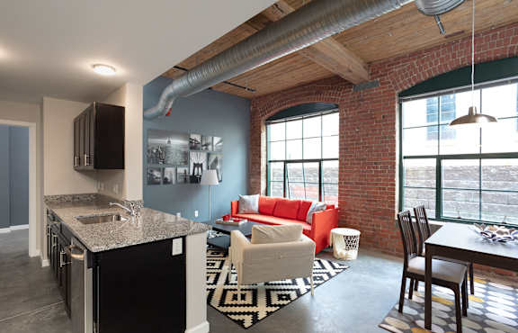 a living room and kitchen in a loft apartment at Cherry Street Lofts in Bridgeport, CT, 06605