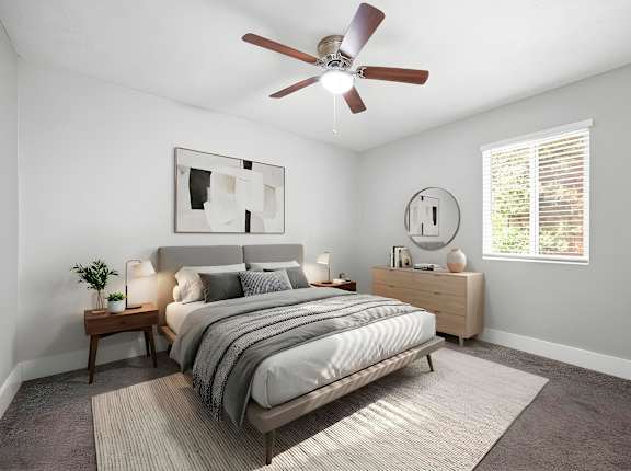 A bedroom with a bed, nightstand, and a ceiling fan.
