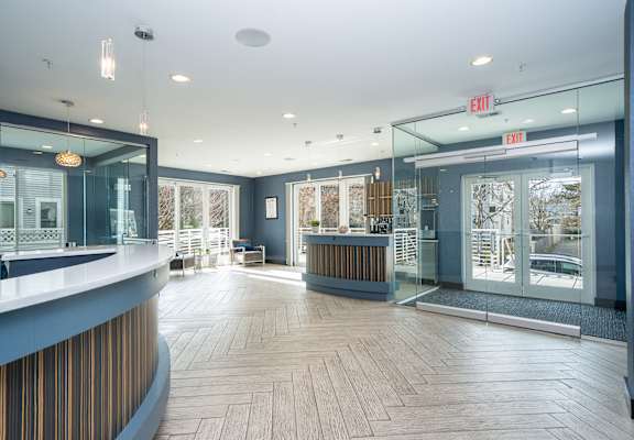 a lobby with a reception desk and glass doors