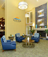 A living room with blue chairs and a fireplace.