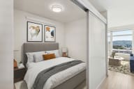 a bedroom with a large bed and a sliding glass door to a balcony