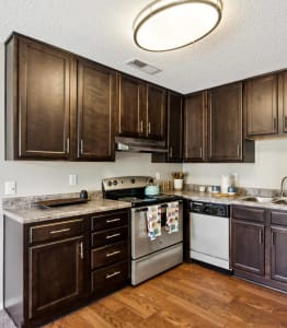 a kitchen with stainless steel appliances and dark wood cabinets