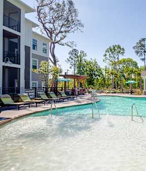 A large outdoor swimming pool with a fountain in the middle.