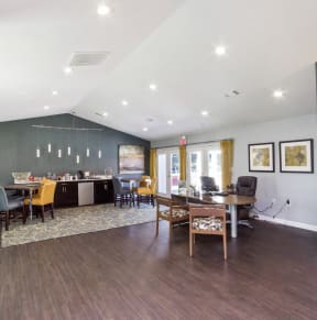 a living room with a dining room and a desk with a chair and a table