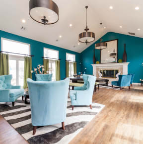 a living room with blue chairs and a fireplace