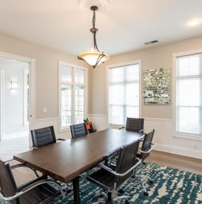 a dining room with a large wooden table and chairs