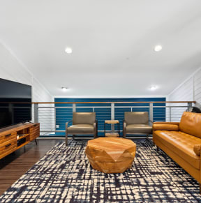 a living room with a leather couch and a television