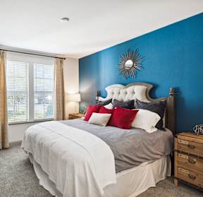 A bedroom with a large bed and a blue wall.