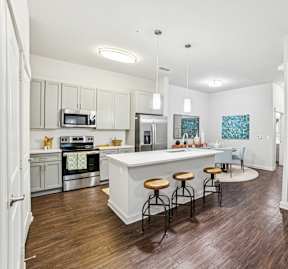 A kitchen with a white island and stools.