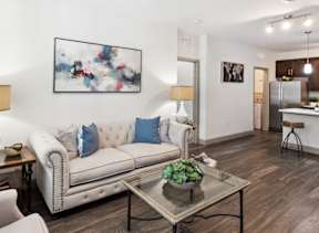 A modern living room with a white sofa and a glass coffee table.