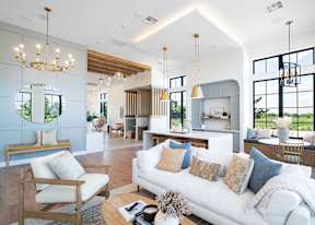 A modern outdoor living space with a stone fireplace and wooden furniture.