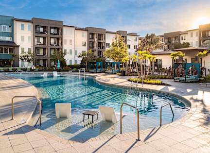 A pool area with a canopy and lounge chairs. at AVLI AT CROSSTOWN CENTER Apartments , TAMPA, FL, 33619