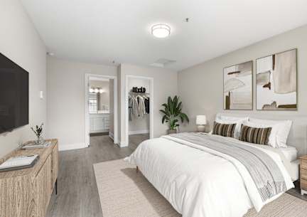 A bedroom with a large bed, a wooden nightstand, and a TV on the wall.