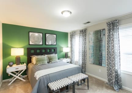 a bedroom with green walls and a bed and a window