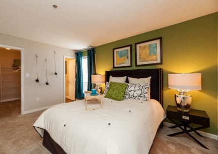 a bedroom with green walls and a white bed