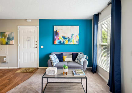 a living room with a blue wall and a couch and a coffee table
