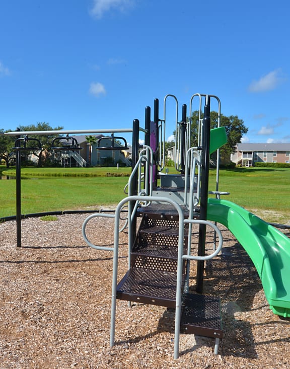 a playground at a park with a green slide