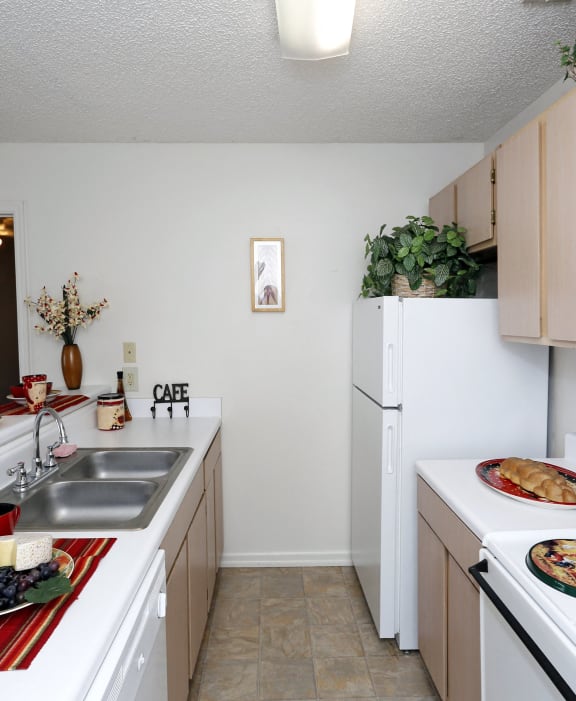 a kitchen with white appliances and a counter with plates of food