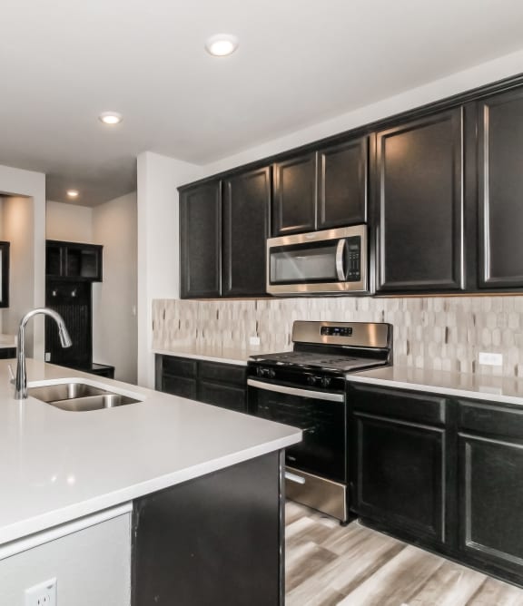a kitchen with white countertops and black cabinets