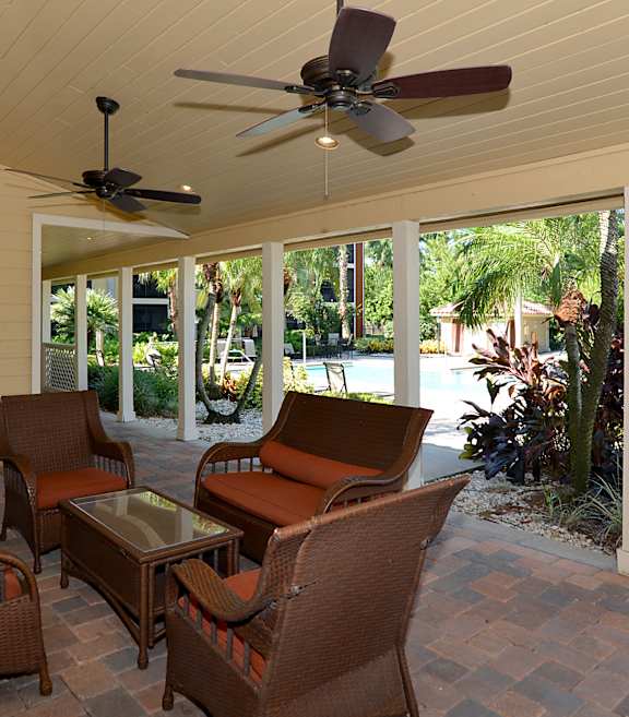 A patio with a ceiling fan and chairs.