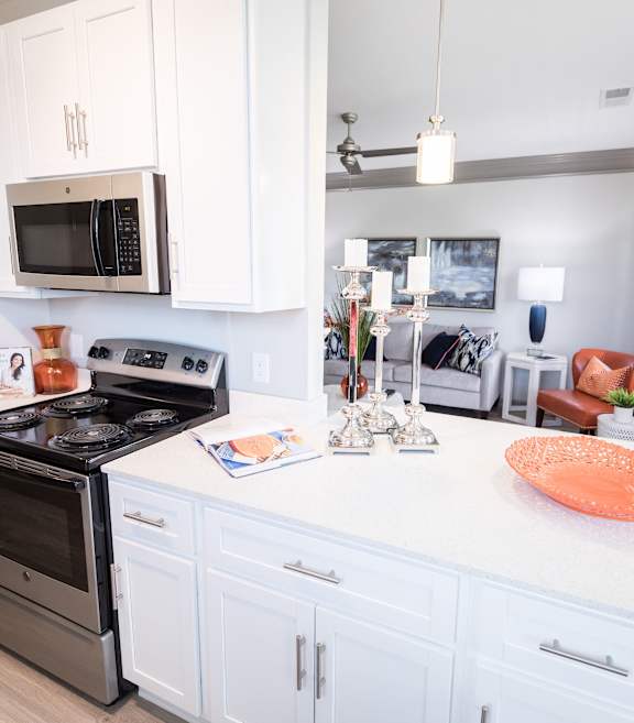 A kitchen with white cabinets and a black stove top.