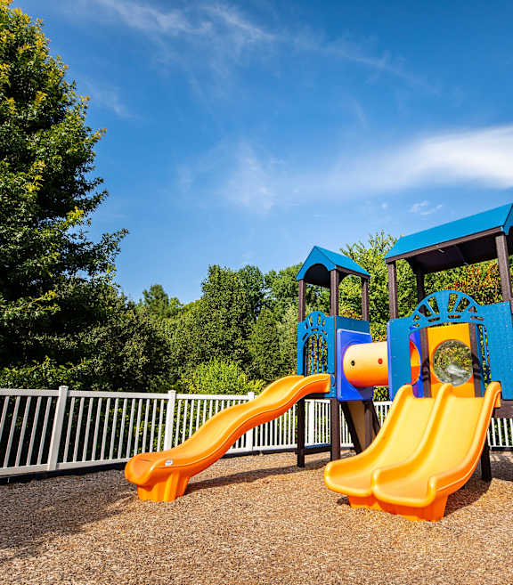 A playground with a blue and orange slide.