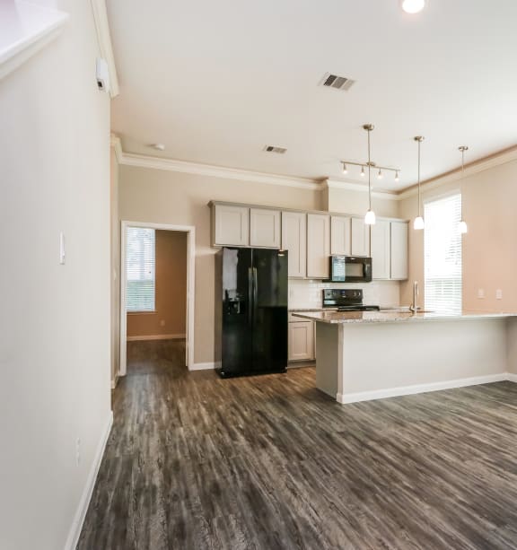 a kitchen with white cabinets and a stainless steel refrigerator