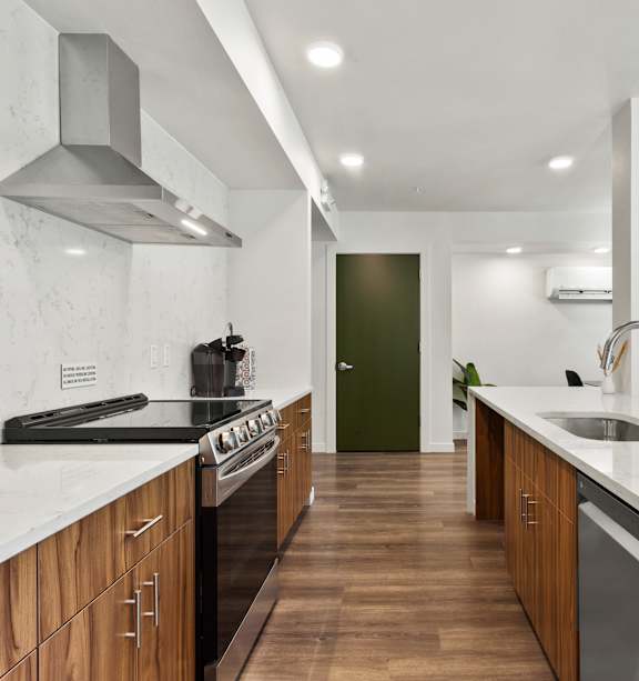 A modern kitchen with wooden cabinets and a marble countertop.