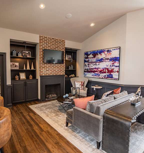 A living room with a fireplace and a TV on the wall.