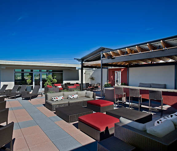 A swimming pool surrounded by lounge chairs and trees.