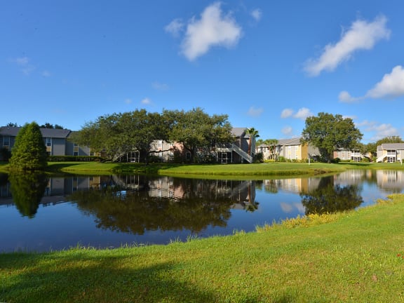 a large pond with houses and trees around it