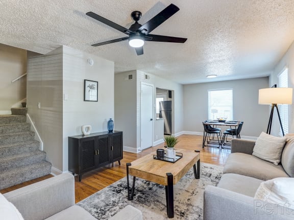 a living room with a couch and a coffee table and a ceiling fan
