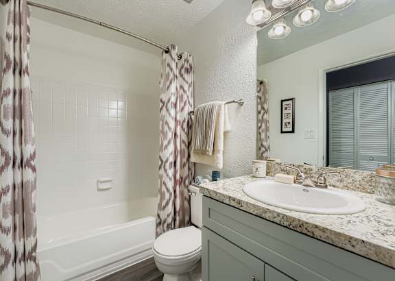 A bathroom with a toilet, sink, and shower.