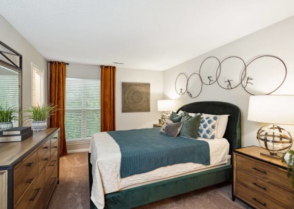 a bedroom with a bed and a dresser and a window
