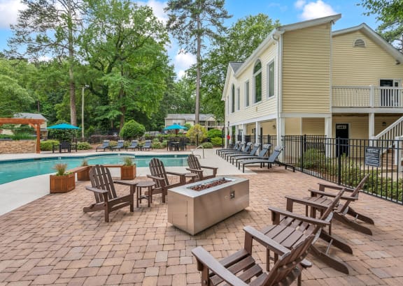 a patio with chairs and a pool and a house