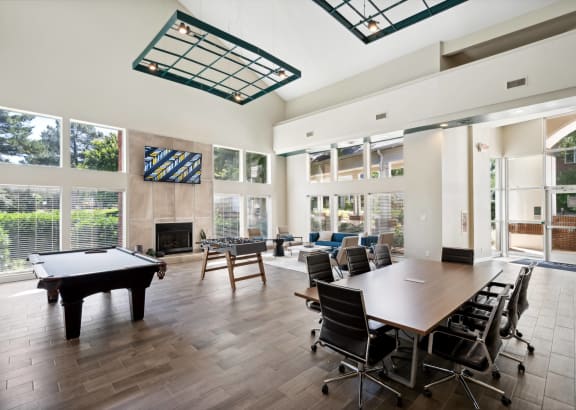 a conference room with a table and chairs and a pool table