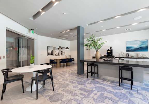 A modern kitchen and dining area with a bar and chairs.