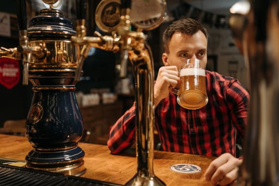 a man drinking a beer in a bar