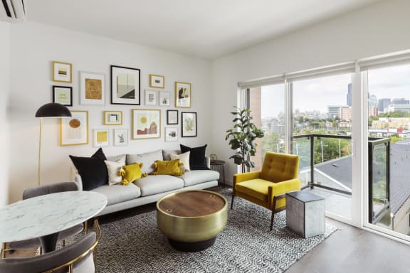 a living room with a white couch and yellow chairs and a large window