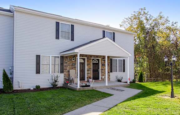 A white house with a black door and a porch.