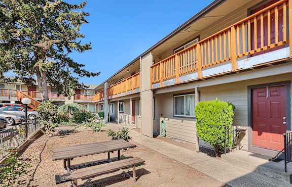 A sunny day at a residential area with apartment buildings and a picnic table.